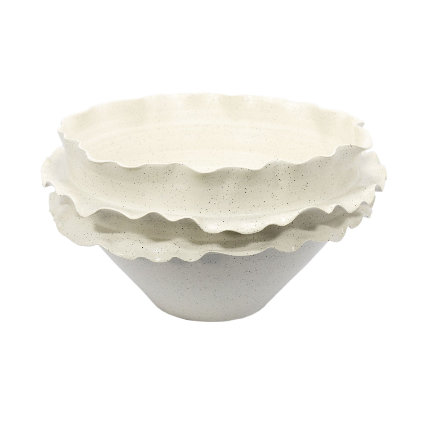 Este é um centro de mesa cerâmico com uma série de ondulações graciosas em sua borda, lembrando as pétalas de uma flor aberta ou as ondas do mar. A cor é um creme suave, com minúsculos pontos pretos distribuídos por toda a superfície, dando a impressão de um granito claro. A peça tem uma base sólida e parece robusta ao toque, com suas bordas onduladas criando uma forma suavemente irregular.